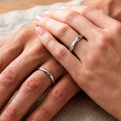 Mãos de um casal usando as alianças de namoro Infinito em prata 925