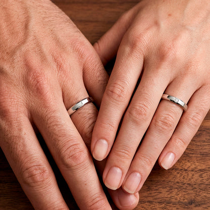 Mãos de um casal usando as alianças de namoro Itália Chanfrada em prata 925