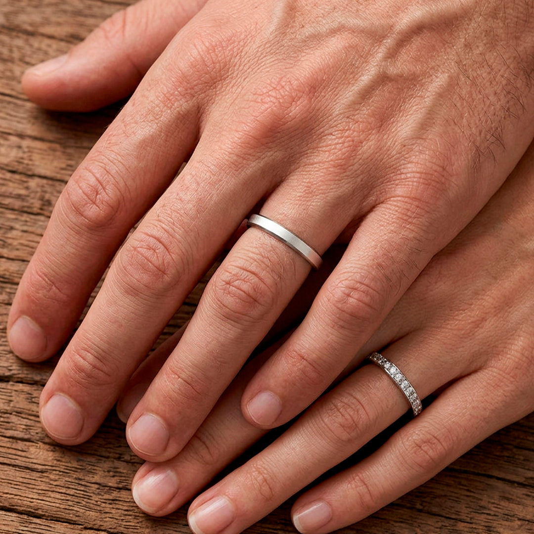 Mãos de um casal usando as alianças de namoro Itália Chanfrada em prata 925