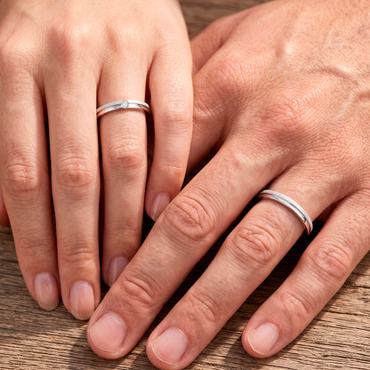 Mãos de um casal usando as alianças de namoro Polaris Diamantada em prata 925