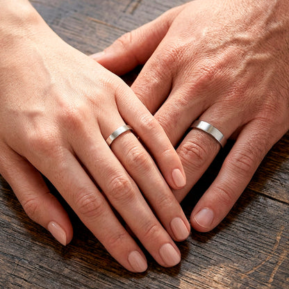 Mãos de um casal usando as alianças de namoro Reta em prata 925